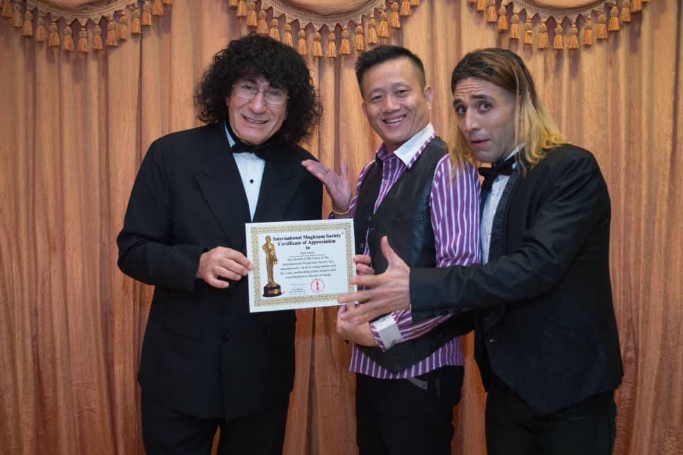 Sam Kwee receiving award from International Magicians Society